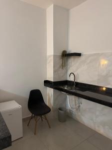 een badkamer met een zwarte wastafel en een zwarte stoel bij Hey Mar Suites in Arraial do Cabo
