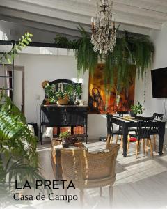 een woonkamer met een eettafel en een kroonluchter bij La Preta, casa de campo in San Clemente