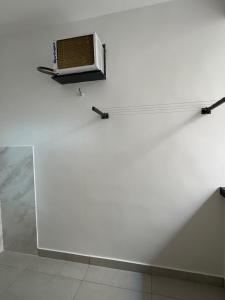 een witte muur met daarop een magnetron bij Hey Mar Suites in Arraial do Cabo