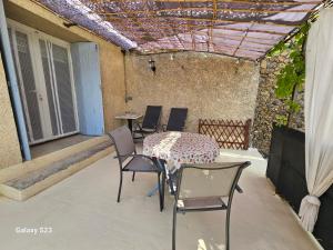 a patio with a table and chairs on a patio at gite ventoux in Puyméras