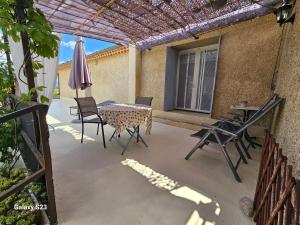 a patio with a table and chairs and an umbrella at gite ventoux in Puyméras +2 photos