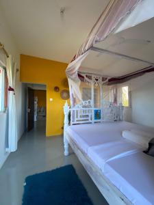 une chambre avec un lit blanc à baldaquin dans l'établissement Watamu Sleek Suites, à Watamu