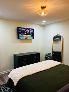 ein Schlafzimmer mit einem Bett und einem Fernseher an der Wand in der Unterkunft Modern Decatur Apt B near Emory, Midtown, Downtown in Decatur