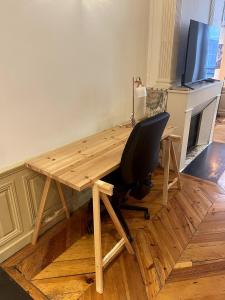 Le charme du Puy dans une ancienne verrerie في لو بوي: مكتب خشبي مع كرسي في الغرفة