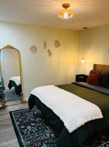 ein Schlafzimmer mit einem großen Bett und einem Spiegel in der Unterkunft Modern Decatur Apt B near Emory, Midtown, Downtown in Decatur
