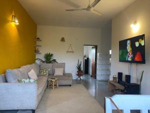 un salon avec un canapé et un ventilateur de plafond dans l'établissement Watamu Sleek Suites, à Watamu