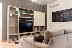 Intero appartamento rinnovato con 3 camere da letto في كامبورا سان جيوفاني: غرفة معيشة مع أريكة وتلفزيون بشاشة مسطحة