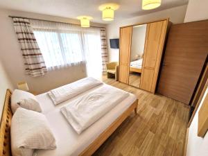 Un dormitorio con una cama grande y un espejo. en Schiestl, en Ramsau im Zillertal