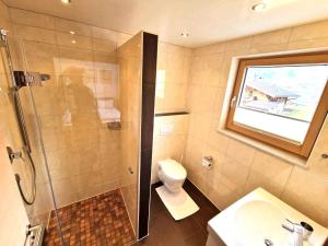 Un baño con ducha, inodoro y lavabo. en Schiestl, en Ramsau im Zillertal 16 fotos más