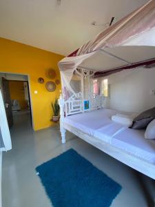 une chambre avec un lit blanc à baldaquin dans l'établissement Watamu Sleek Suites, à Watamu 1 autre photo