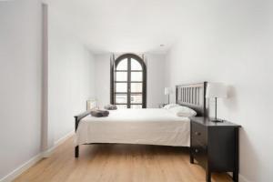 ein weißes Schlafzimmer mit einem großen Bett und einem Fenster in der Unterkunft AVG Numa Guilhou 4 in Gijón