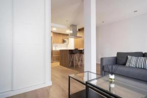 ein Wohnzimmer mit Sofa und Tisch in der Unterkunft AVG Numa Guilhou 4 in Gijón + 16 Fotos