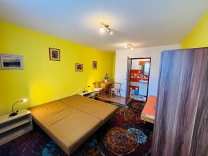 a bedroom with a bed and a yellow wall at Apart-Bungalovy Gitka in Mlynčeky