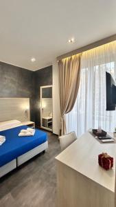 a bedroom with a bed and a desk and a window at B&B Margherita in Messina