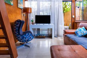 a living room with a couch and a chair and a television at Pousada e Chalé Lote 22 in Ilha do Mel