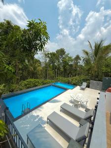 ein Pool mit einem Tisch und Stühlen daneben in der Unterkunft Riyavar Luxury Stay in Siddapur