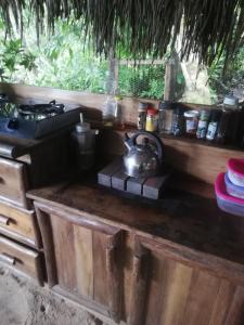a tea kettle sitting on top of a wooden counter at casa colibri cañón de rio dulce in Lívingston