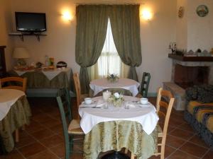 a dining room with two tables and a fireplace at Agriturismo Colleverde Capalbio in Capalbio