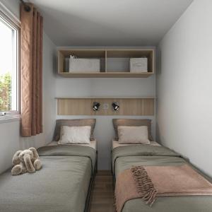 zwei Betten in einem kleinen Zimmer mit einem Teddybären in der Unterkunft Camping 4 étoiles - Parc aquatique - ccbcafh in Jugon Les Lacs