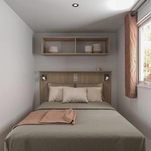 ein Schlafzimmer mit einem Bett mit einer Decke darauf in der Unterkunft Camping 4 étoiles - Parc aquatique - ccbcafh in Jugon Les Lacs