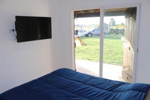 a bedroom with a bed and a flat screen tv at Casa Slide en Chapadmalal in Colonia Chapadmalal