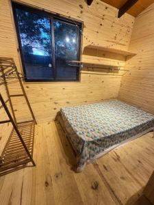 a room with a bed in a cabin with a window at Amanda Relax and nature beautiful beach in Playa Hermosa