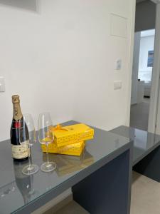 a bottle of wine and two wine glasses on a table at B&B Cariddi Rooms in Caltanissetta +5 photos