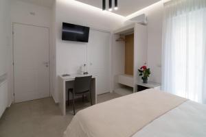 a white bedroom with a desk and a bed at B&B Cariddi Rooms in Caltanissetta
