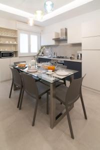 a kitchen with a dining table and chairs in a kitchen at B&B Cariddi Rooms in Caltanissetta