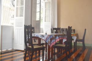 a dining room with a table and chairs and windows at Palacete Carmen in Belém