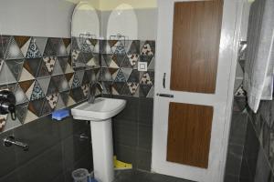 um banheiro com uma pia e um espelho em Ghar Homestay em Kulu