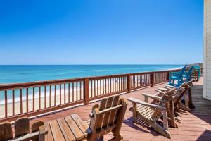 eine Reihe von Holzbänken auf einer Promenade in der Nähe des Strandes in der Unterkunft 8045 - Mirlo Hi in Rodanthe