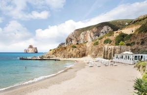 een strand met stoelen en een gebouw en de oceaan bij Casalileo in San Giovanni Suèrgiu