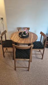 a wooden table with two chairs and a table with flowers on it at Cockermouth Cottage - Lakes - Parking in Cockermouth