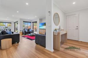a living room with a couch and a mirror at Central Echuca Escape, Heated Pool, 3 BDR in Echuca