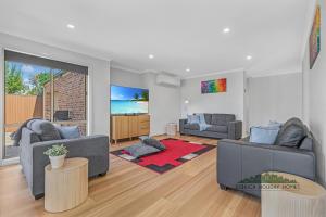 a living room with two couches and a tv at Central Echuca Escape, Heated Pool, 3 BDR in Echuca