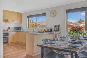 a kitchen with a table and a clock on the wall at Central Echuca Escape, Heated Pool, 3 BDR in Echuca +9 photos