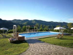 a swimming pool with two chairs and a playground at Tenuta MonteOliveto - Cottage Relax - Agriturismo nelle Langhe in Vesime