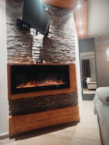 einen Kamin mit einem TV an einer Steinmauer in der Unterkunft Lela Kop in Kopaonik + 72 Fotos