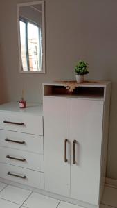 eine weiße Kommode mit einer Topfpflanze darauf in der Unterkunft Apartamento no centro de Ananindeua in Ananindeua