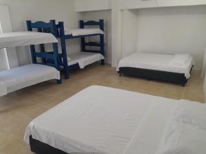 ein Zimmer mit drei Etagenbetten und Fliesenboden in der Unterkunft Cabaña Palma Azul in Coveñas + 18 Fotos