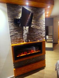 ein Kamin in einem Wohnzimmer mit einem Fernseher darüber in der Unterkunft Lela Kop in Kopaonik