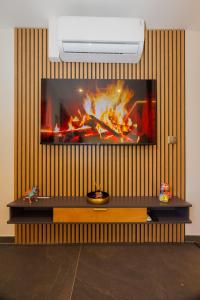 una tv su un muro con un fuoco sopra di ELYSIA Nature & Spa a Boersch