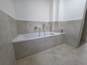 a white tub in a bathroom with a tile floor at Malerischer Panoramablick Worgberg in Ingelfingen