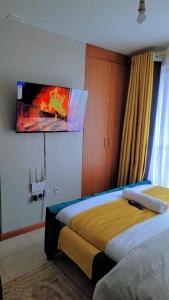 una camera d'albergo con due letti e una TV a parete di Comfy Homes By Becca a Nairobi