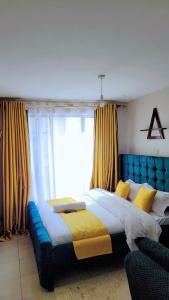 una camera da letto con un letto grande e una grande finestra di Comfy Homes By Becca a Nairobi