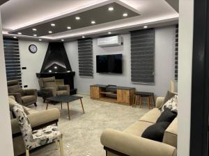 a living room with a tv and a couch and chairs at Veray Homes Villa in Ayios Dhometios