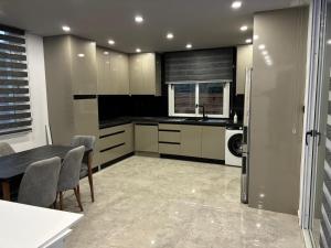 a kitchen with white cabinets and a table with chairs at Veray Homes Villa in Ayios Dhometios