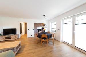 a living room with a table and chairs and a tv at kleines KunzGlück in Waldbronn