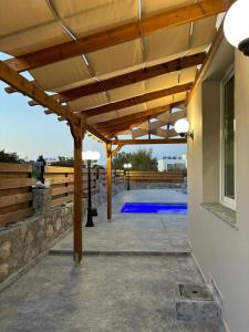 a patio with a wooden pergola and a swimming pool at Veray Homes Villa in Ayios Dhometios